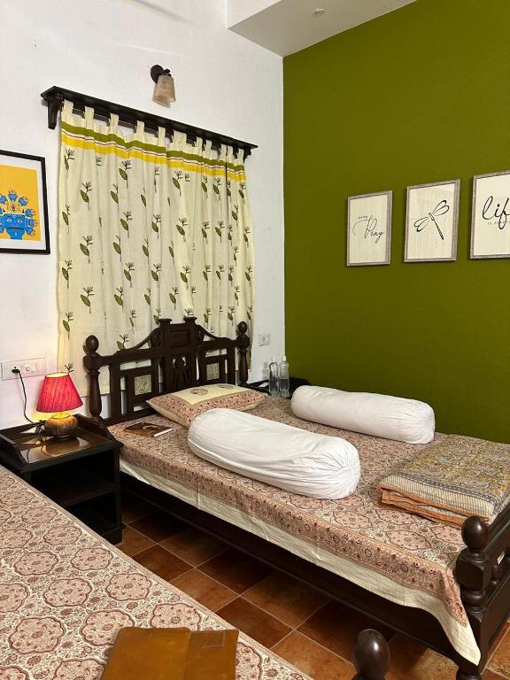 two twin beds in a room with green walls at Junput Guest House in Bichania