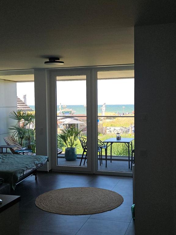 a room with a view of a patio with a table at Fewo Ostseeparadies Meerblick in Graal-Müritz