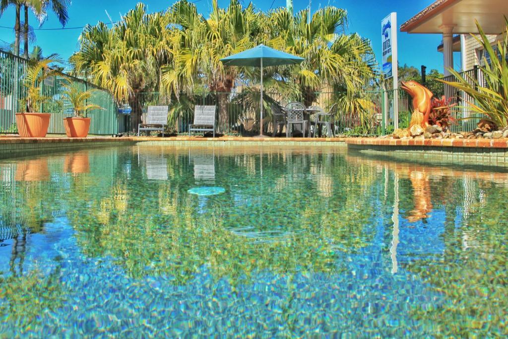 einen Pool in einem Resort mit einem Dinosaurier im Wasser in der Unterkunft Santa Fe Motel and Holiday Units in Lennox Head