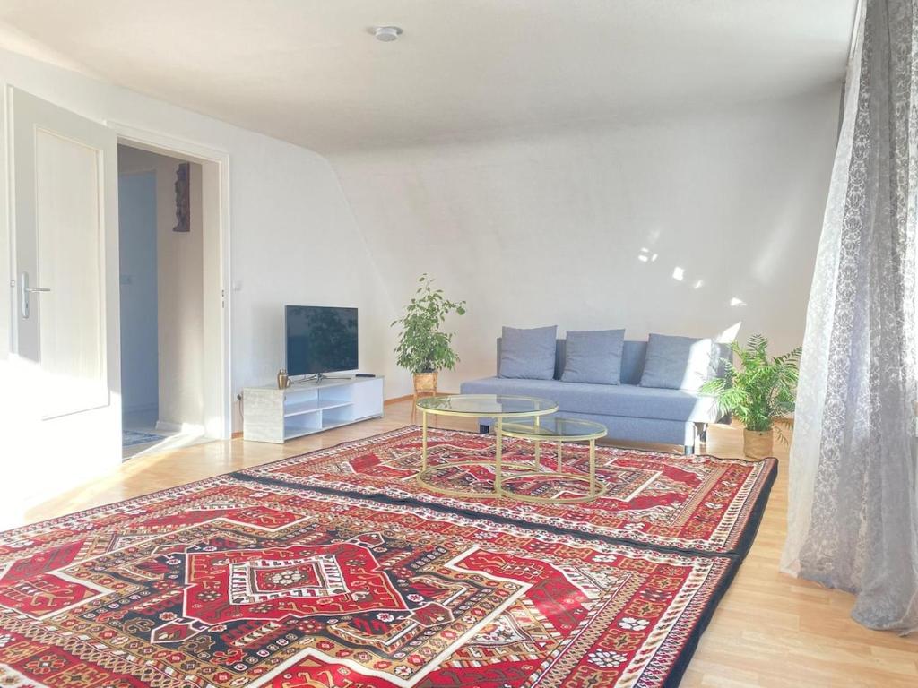 a living room with a blue couch and a rug at Gemütliche Wohnung mit Berg- und Waldblick in Balingen