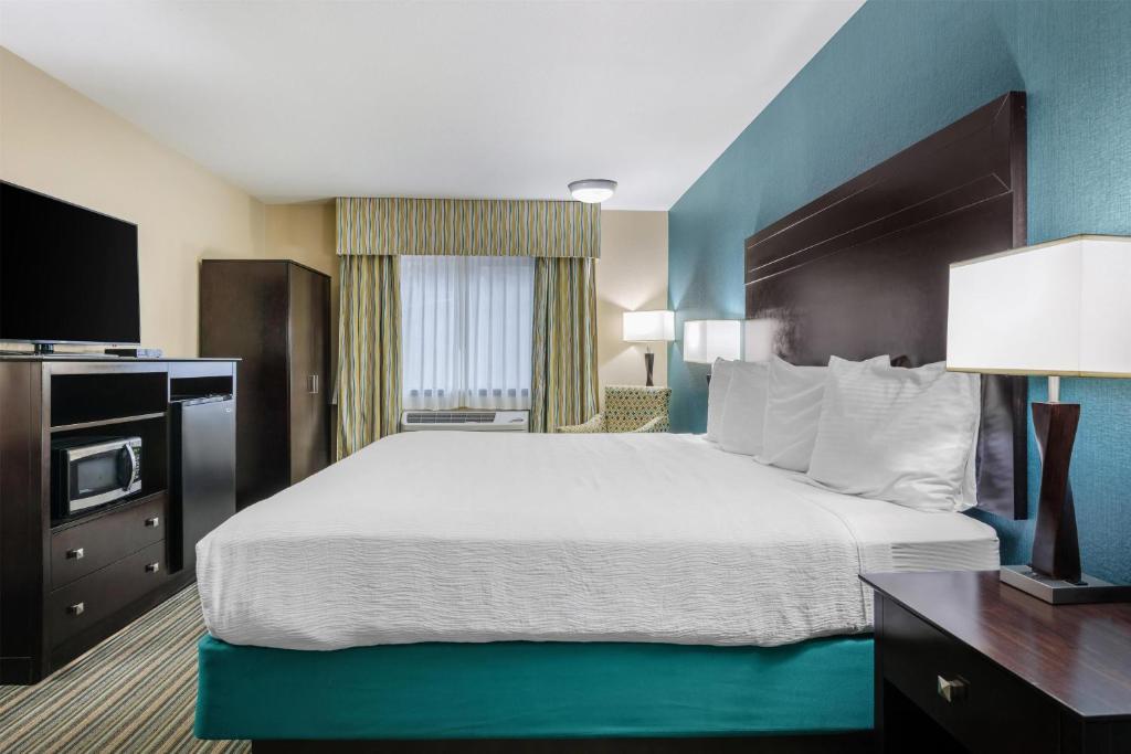 a hotel room with a large bed and a television at Best Western Long Beach Inn in Long Beach