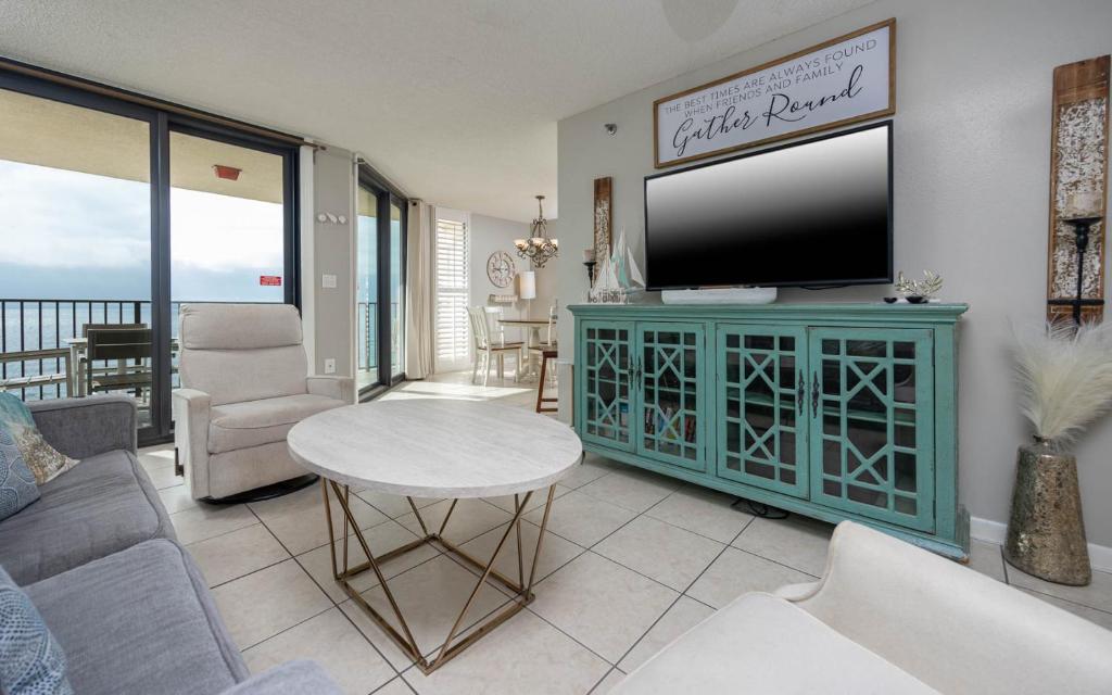 a living room with a flat screen tv on a cabinet at Phoenix East II 2092 in Orange Beach