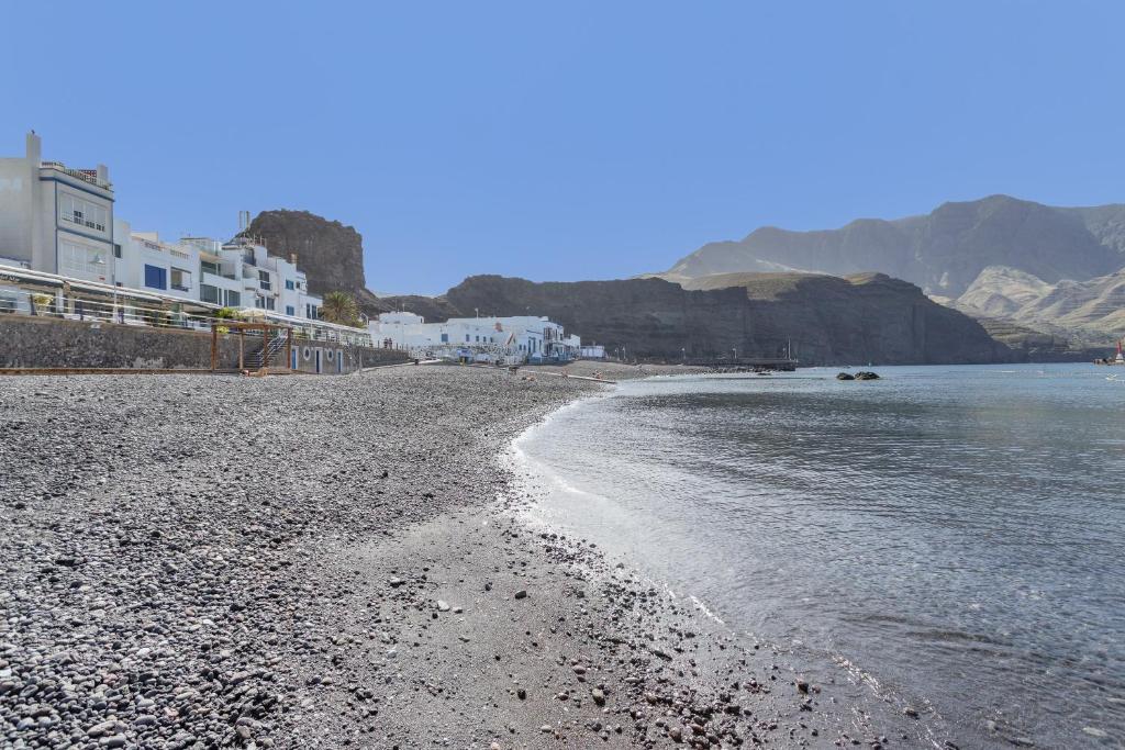 a beach with white buildings and the water at Villa Star in Agaete