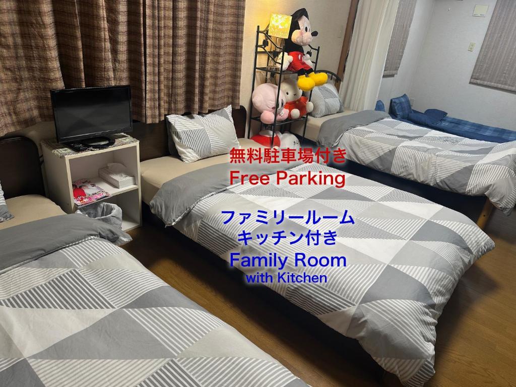 Ein Zimmer mit vier Betten und einem Schild mit der Aufschrift „Kostenloses Parken“ in der Unterkunft Private Inn Bambee in Kōbe