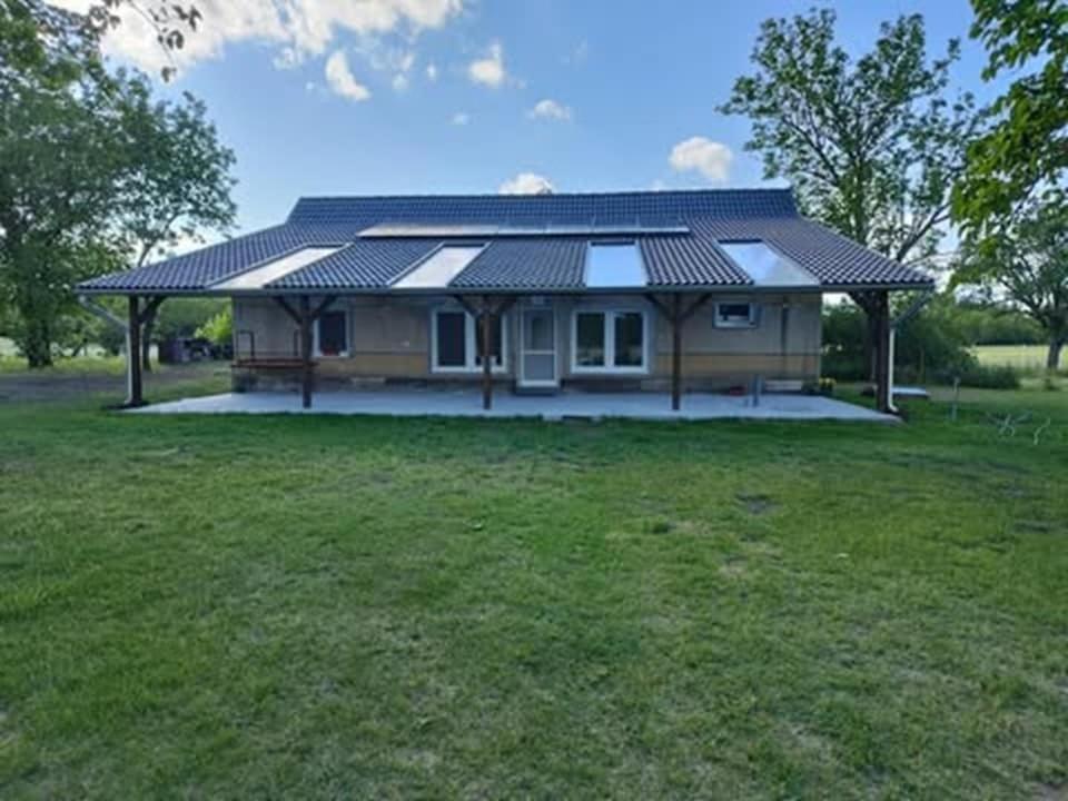 a house with a solar roof on top of a yard at Napfény Tanya in Tázlár