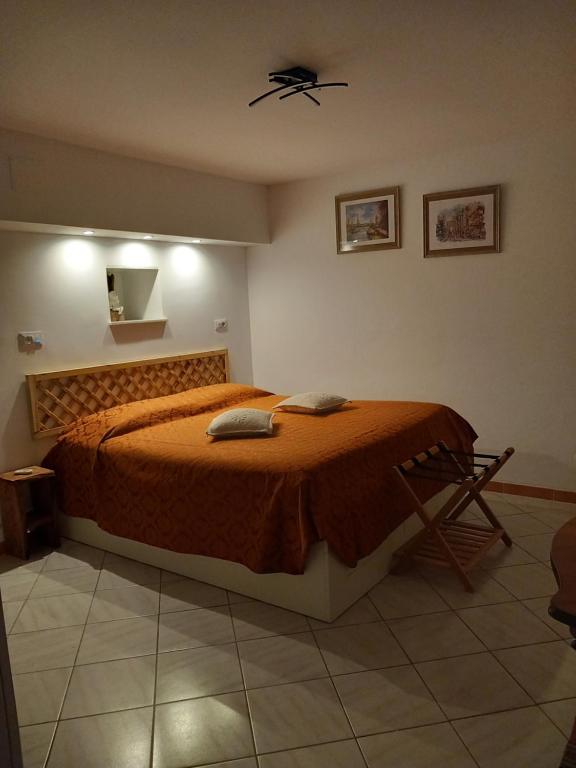a bedroom with a bed with a orange bedspread at Villa Bella Liguria B&B in Favale di Malvaro