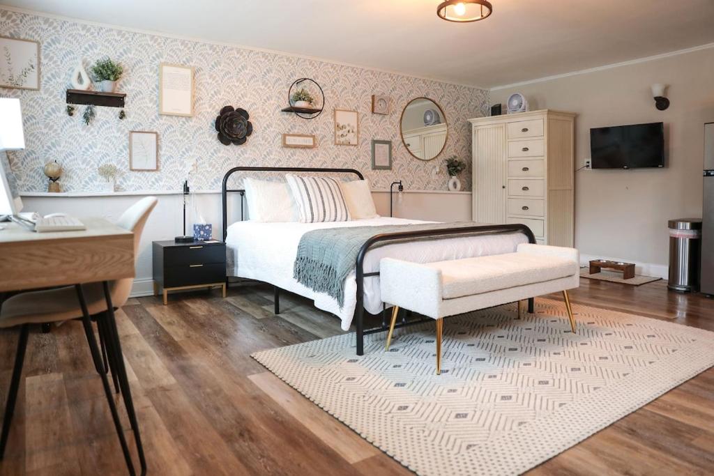een slaapkamer met een bed, een tafel en een bureau bij Modern Cozy Studio in East Windsor