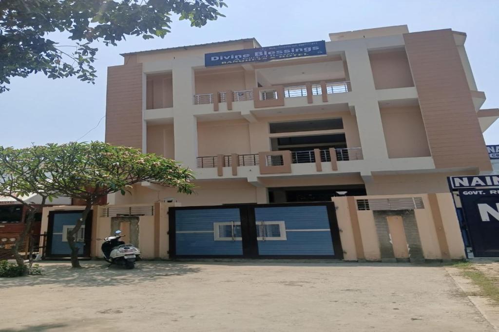 a building with a motorcycle parked in front of it at Divine Blessings Banquet and Hotel in Prayagraj