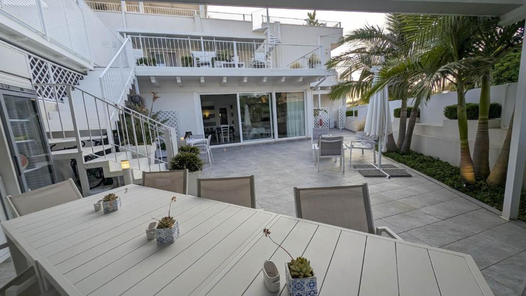 ein weißer Tisch und Stühle auf einer Terrasse in der Unterkunft Arneo Terra del Sole B&B in Torre Lapillo
