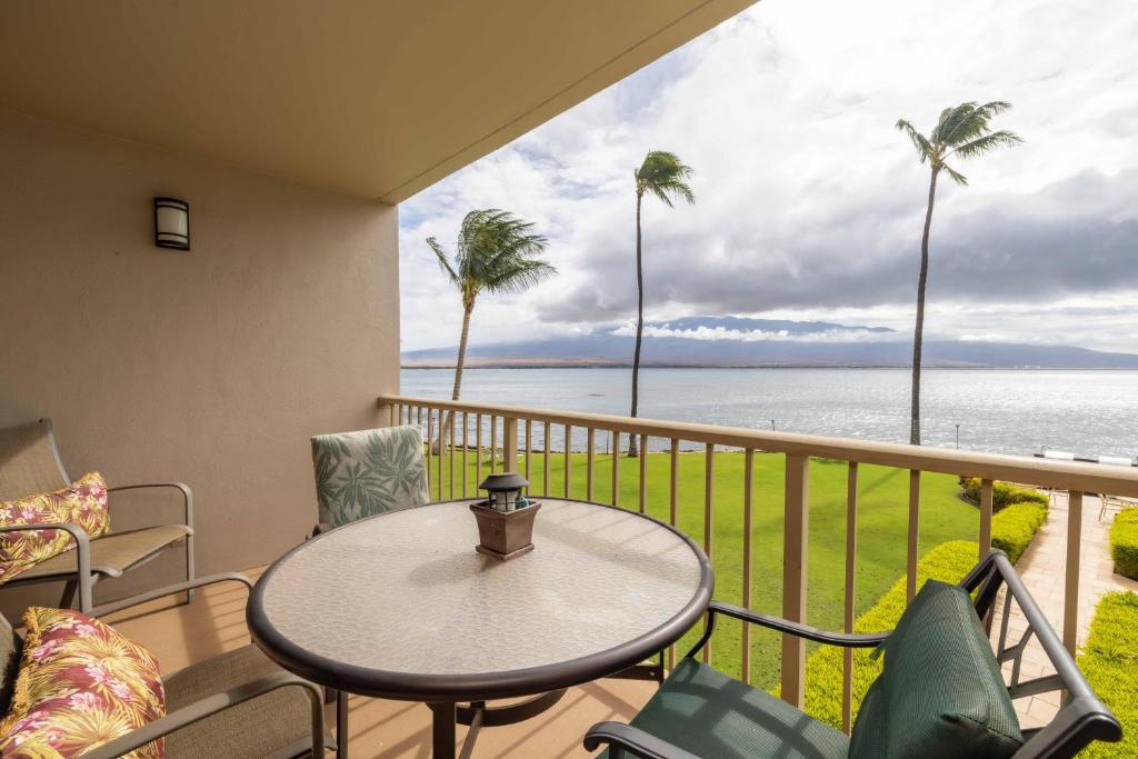 a balcony with a table and chairs and the ocean at Maalaea Kai Resort 213 in Wailuku