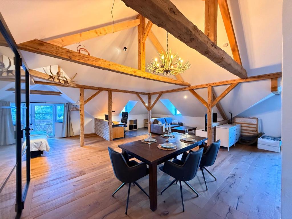 a dining room and living room with a table and chairs at Loft am Wappach in Bayerisch Gmain