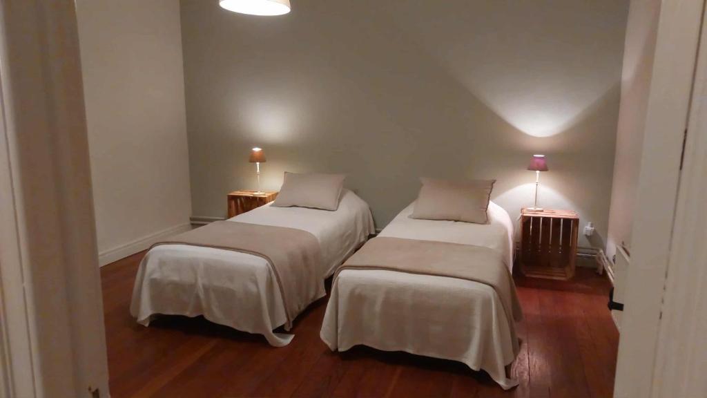 two beds in a room with wood floors at Le Pré en Bulles in Chiny