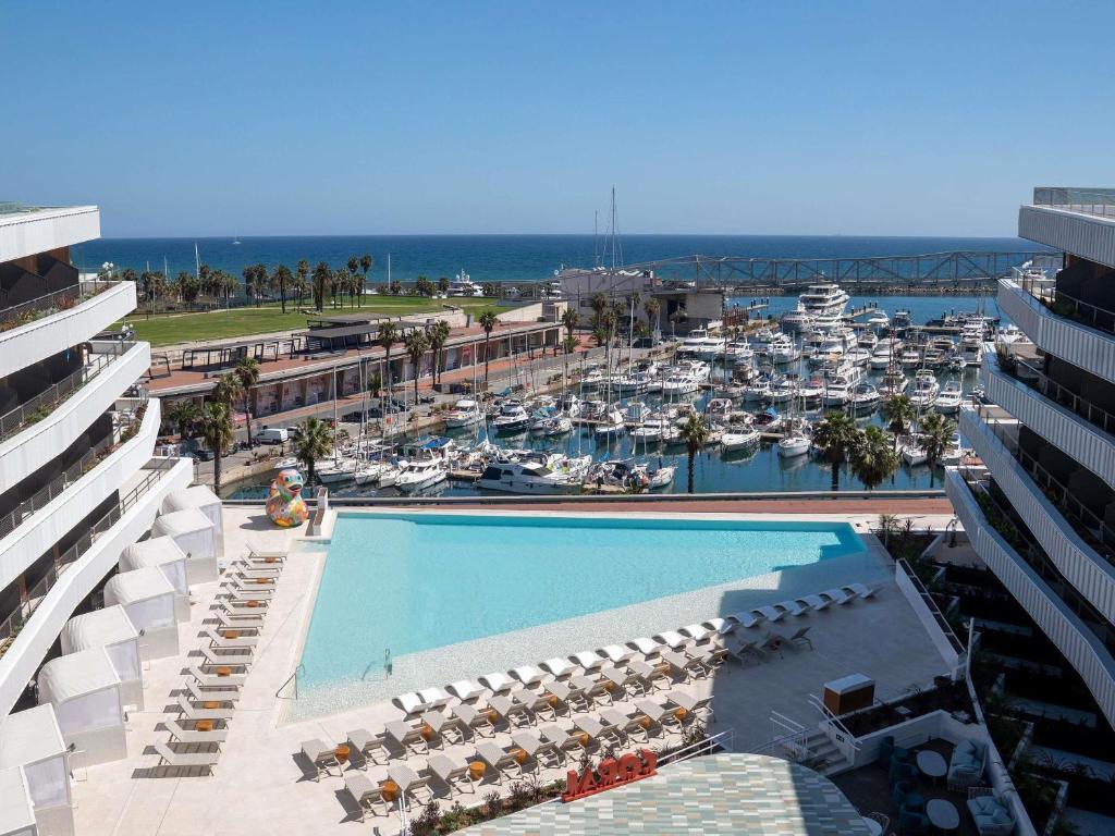 een luchtzicht op een resort met een zwembad en een jachthaven bij SLS Barcelona in Barcelona