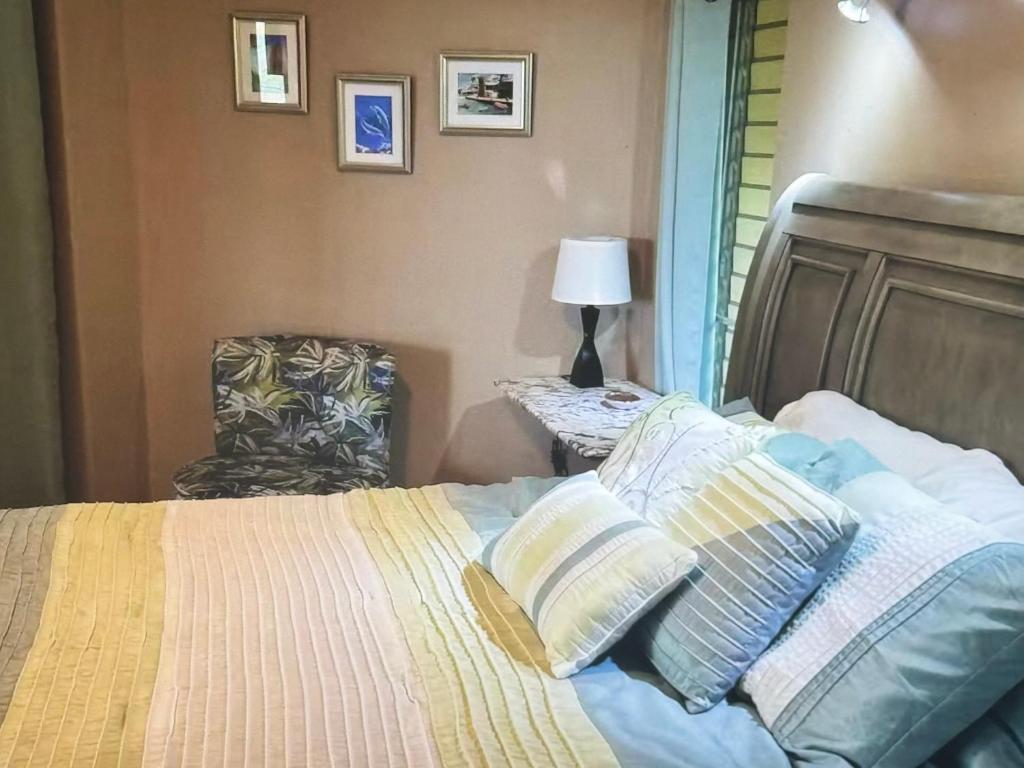 a bedroom with a bed with pillows and a chair at Superbe Zions Hill Views in Sion Farm