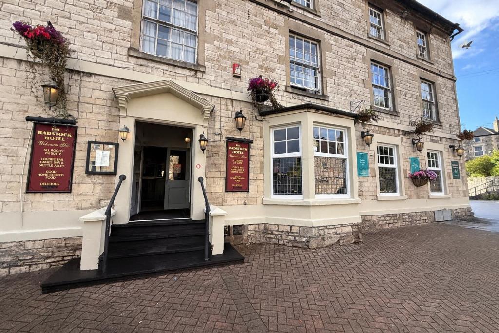een groot bakstenen gebouw met een ingang naar een gebouw bij Radstock Hotel near Bath in Radstock