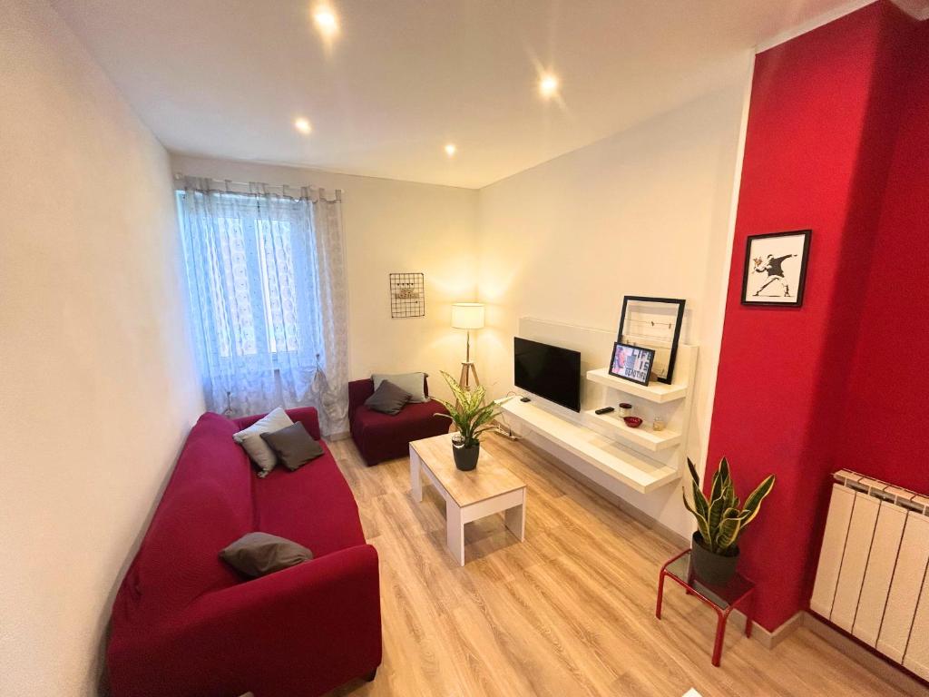 a living room with red furniture and a red wall at Duca - Gorizia City Apartment - 80 smq Central in Gorizia