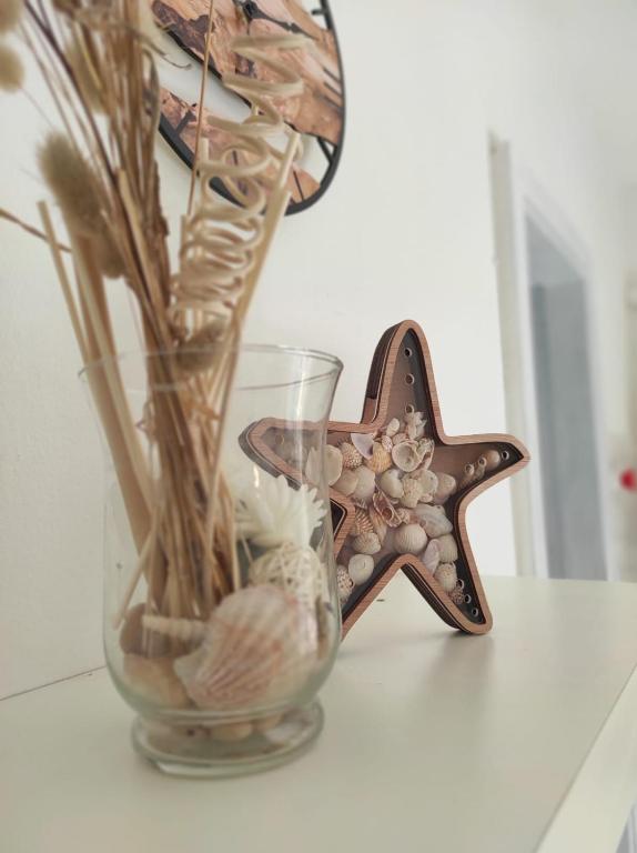 a glass vase with shells and a starfish on a table at casa MAREA in Lido Marini