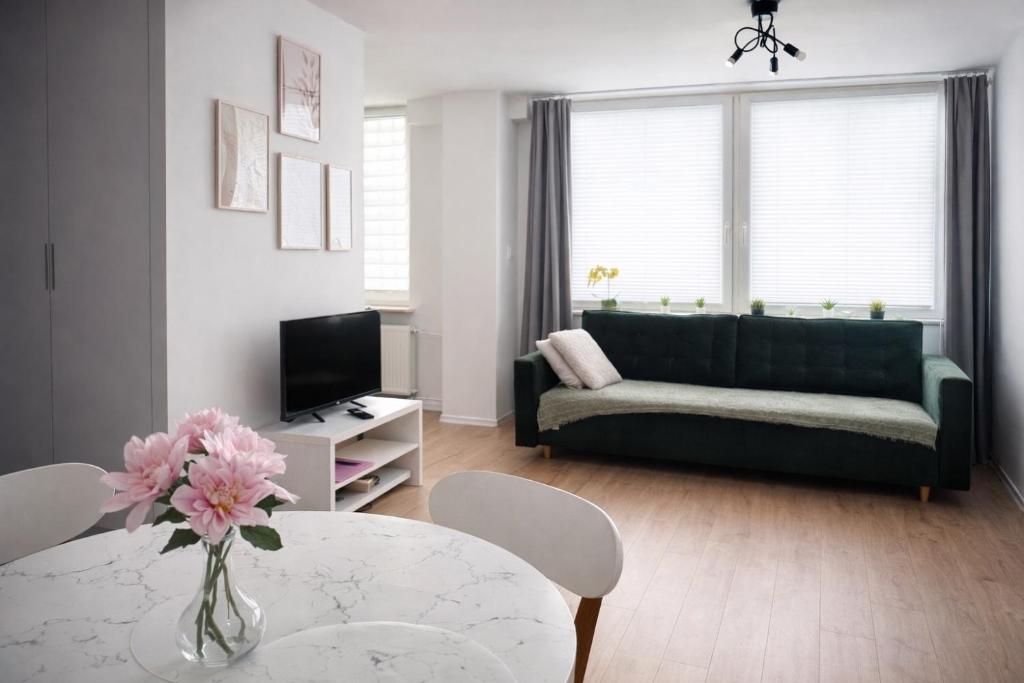 a living room with a green couch and a table at Apartament Świdnik Kosik in Świdnik