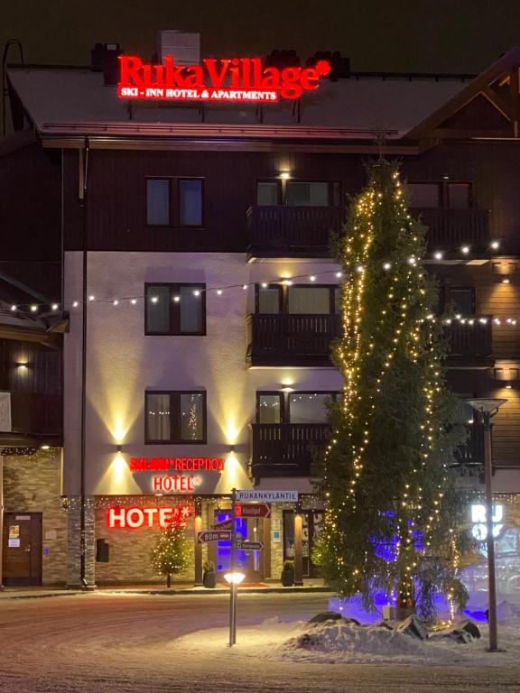 een kerstboom voor een hotel 's nachts bij Ruka Village, 4BR Suite A27, 133m2 in Kuusamo