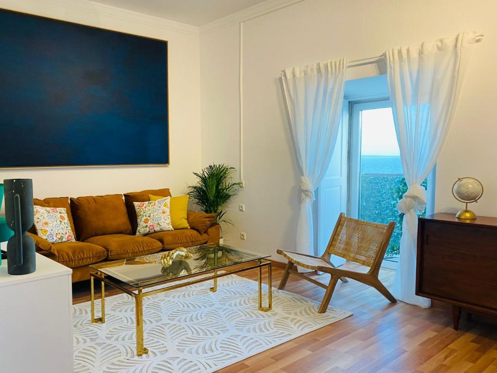 a living room with a couch and a glass table at Ocean Gate Palace in Caxias