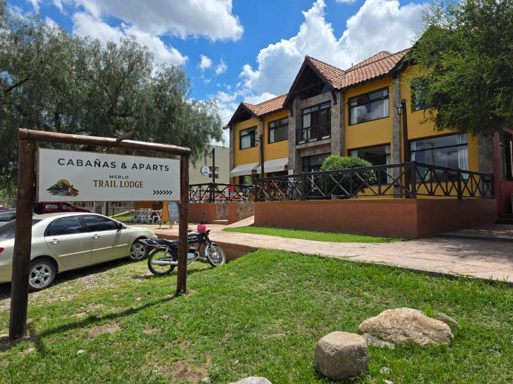 a sign in the grass in front of a building at Merlo Trail Lodge in Merlo
