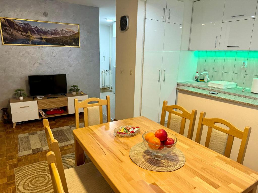 a kitchen and a table with a bowl of fruit on it at Apartman Lana in Pale