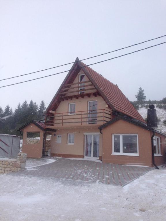 a house with a gambrel roof on top of it at Kuća za odmor Vukas in Kupres