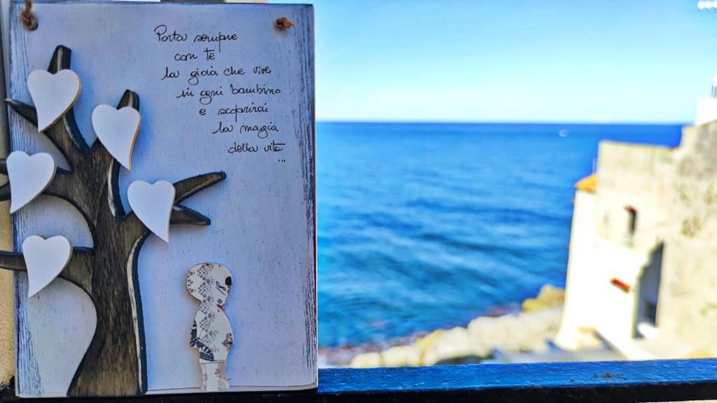 a sign with a tree with hearts on it next to the ocean at Luxury House in Cefalù