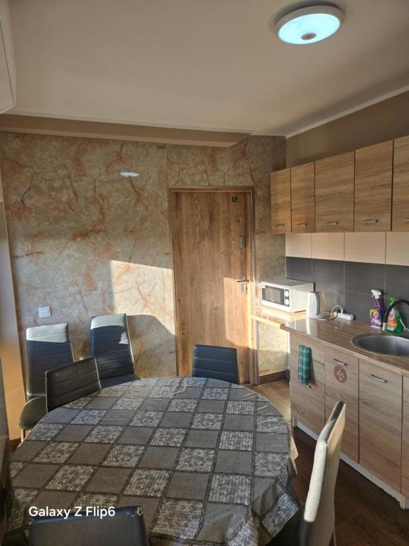 una cucina con tavolo e sedie in una cucina di Hostel Kandulski a Poznań