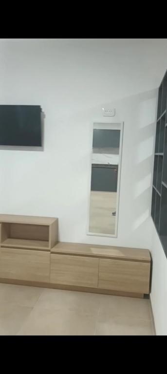 a white room with a mirror and a wooden bench at Loft Urbano Pilar in Del Viso