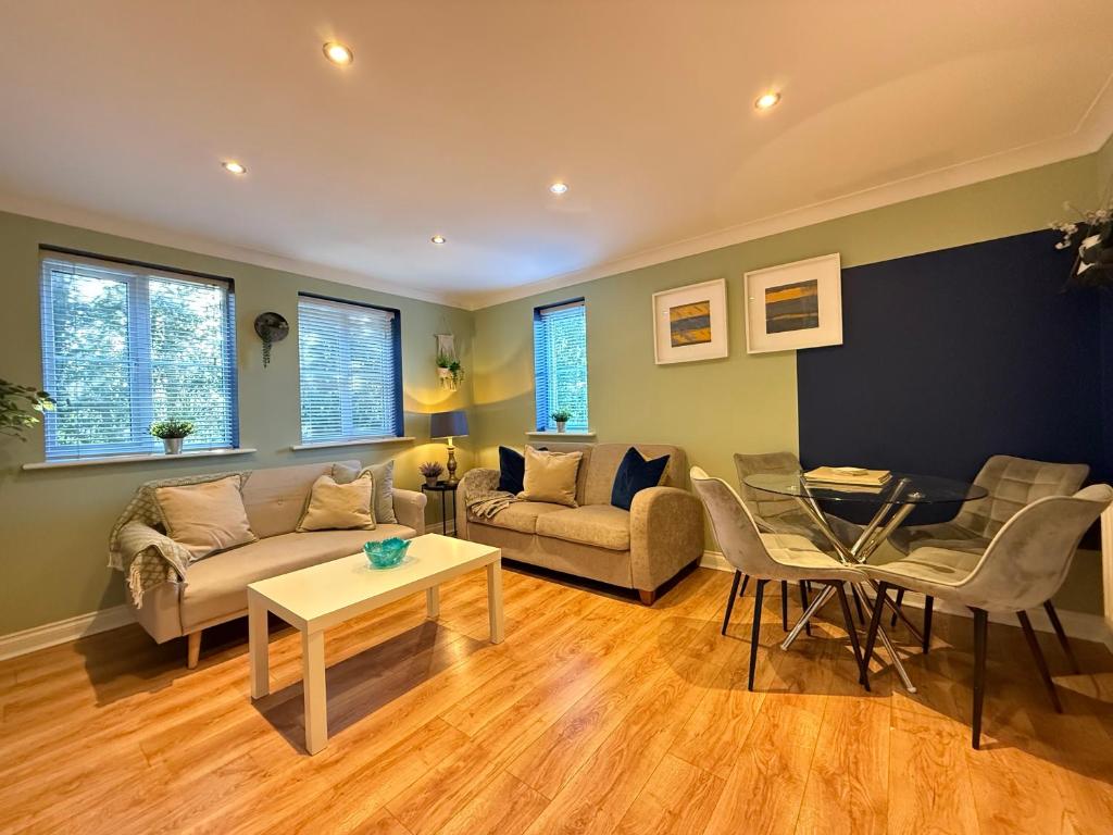 een woonkamer met een bank en een tafel bij GF flat sleeps 4, parking for Contractors by Eagle Owl Stays in Crawley