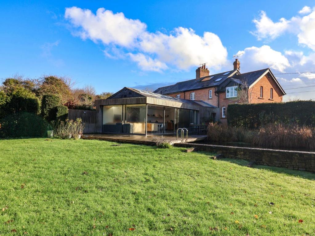 a house with a large lawn in front of it at Bredy Cottages in Bridport
