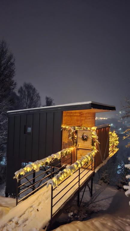a bench covered in christmas lights in the snow at Panoramic Box in Vişeu de Sus