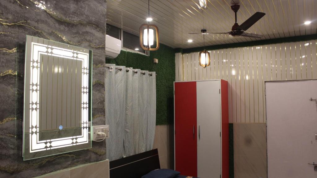 un bagno con un grande specchio e un mobiletto rosso di Dipankar House a Tezpur