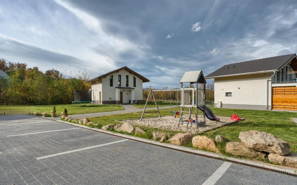 ein Spielplatz in einem Hof neben einem Haus in der Unterkunft Domki z jacuzzi Zacisze w Górach in Sosnowka