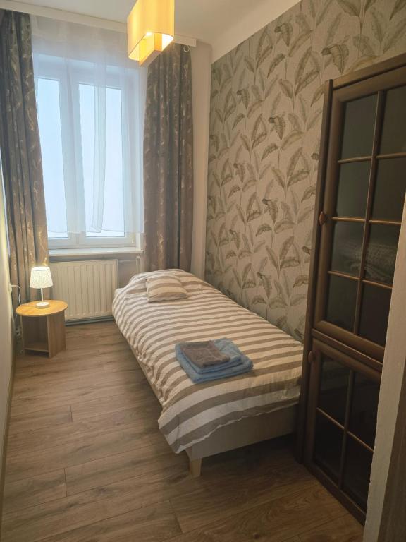 a small bedroom with a bed and a window at Perłowy in Biłgoraj