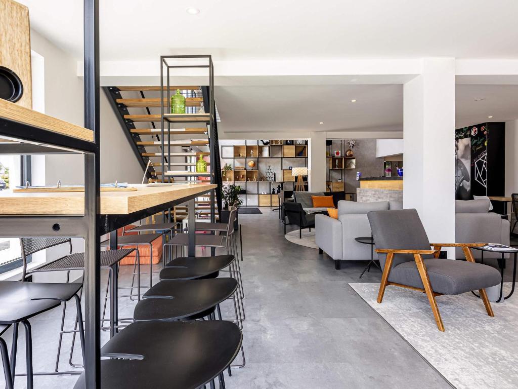 een bar met stoelen en tafels in een kamer bij ibis Dijon Sud in Perrigny-lès-Dijon
