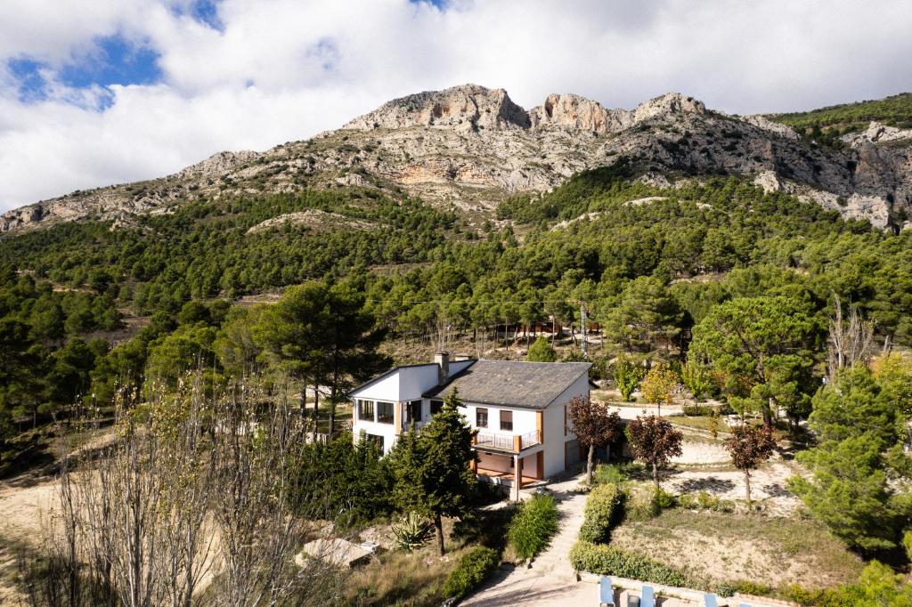 an aerial view of a house in front of a mountain at Mas del Cel - Casa Rural in Confrides