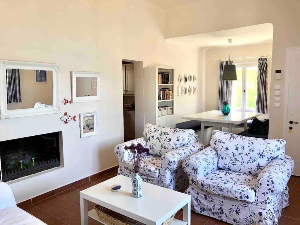 a living room with two couches and a fireplace at Tranquility House Astros in Paralio Astros