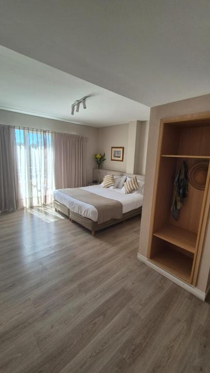 a bedroom with a large bed and a large window at DAKAR HOTEL in Mendoza