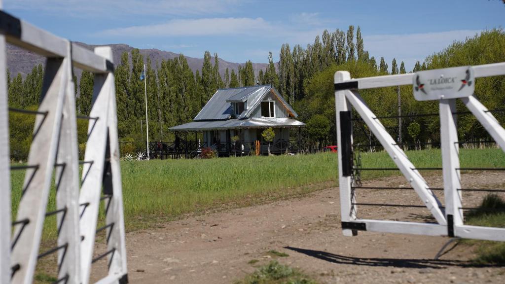 a gate in front of a house with a house at La Loica in El Maitén