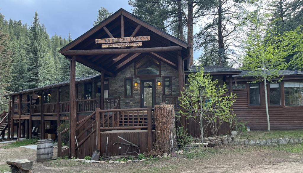 a cabin in the woods with a sign on it at Two Bridges Lodge in Bailey