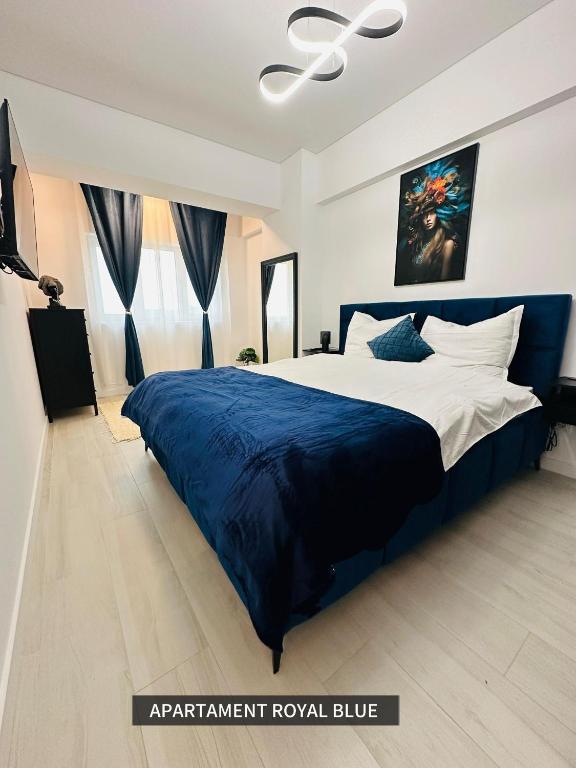 a bedroom with a large bed with a blue blanket at Royal Blue Iasi in Iaşi