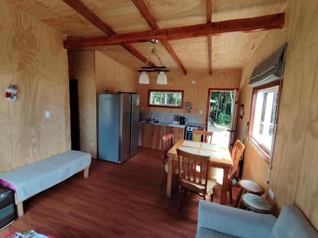 een keuken en eetkamer met een tafel en een koelkast bij Cabaña el Maitén Ensenada in Puerto Varas