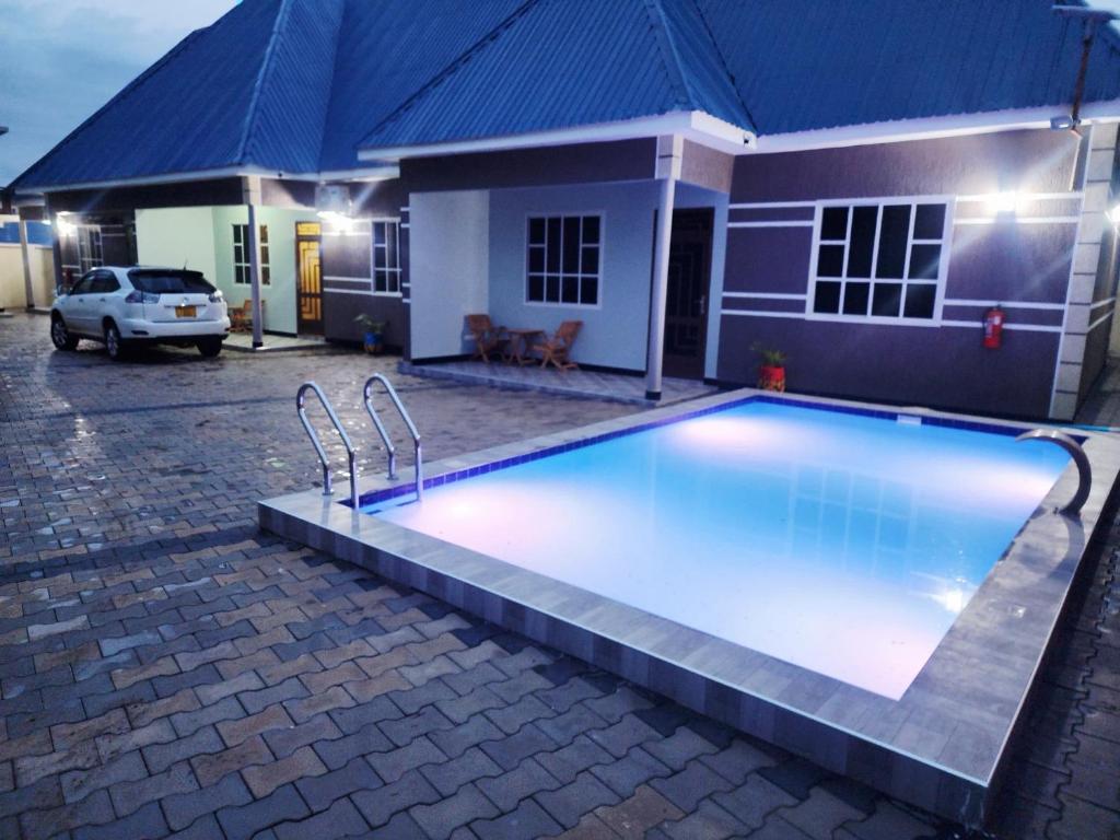 a swimming pool in front of a house at ES Apartments in Dodoma