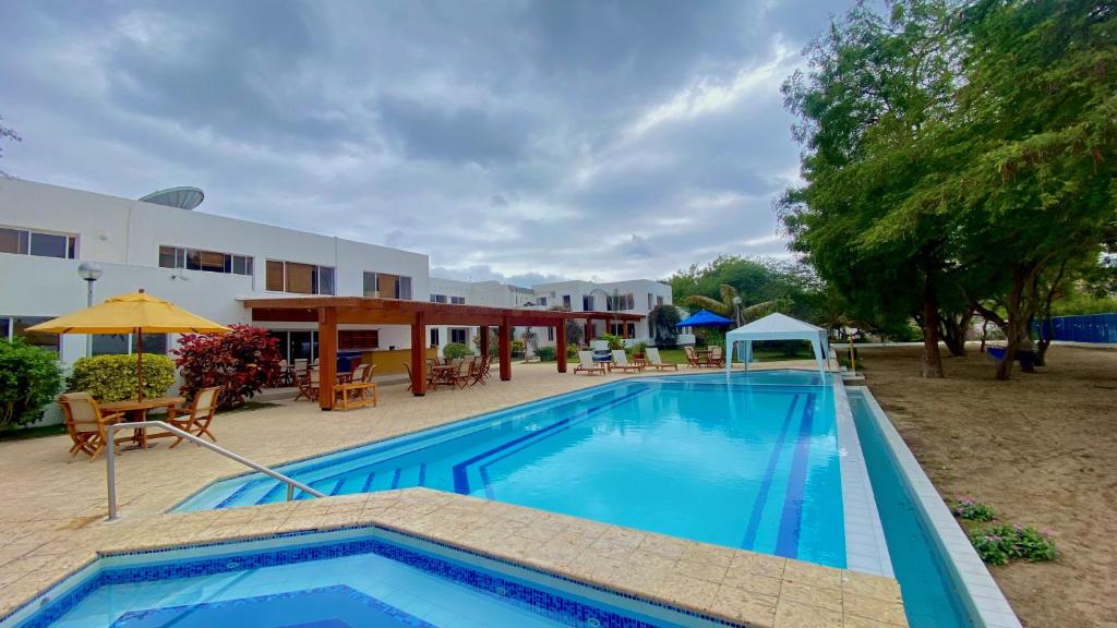 a large swimming pool in front of a building at Hosteria del Parque Machalilla - Los Frailes in Machalilla