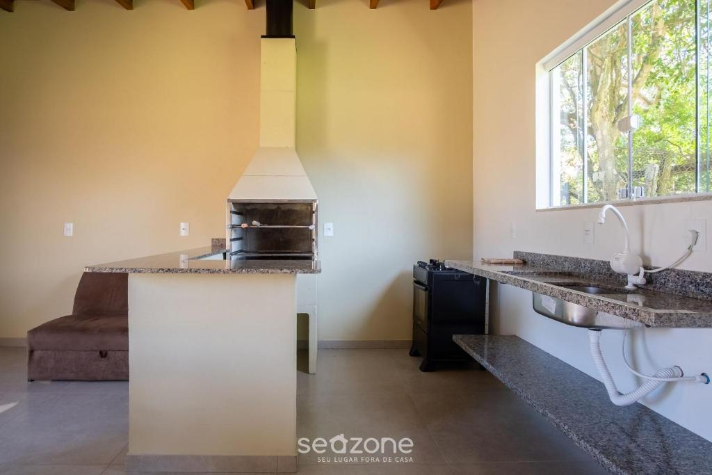 a kitchen with a stove and a sink at 2-Bedroom House with Barbecue Area WIL0012 in Imbituba