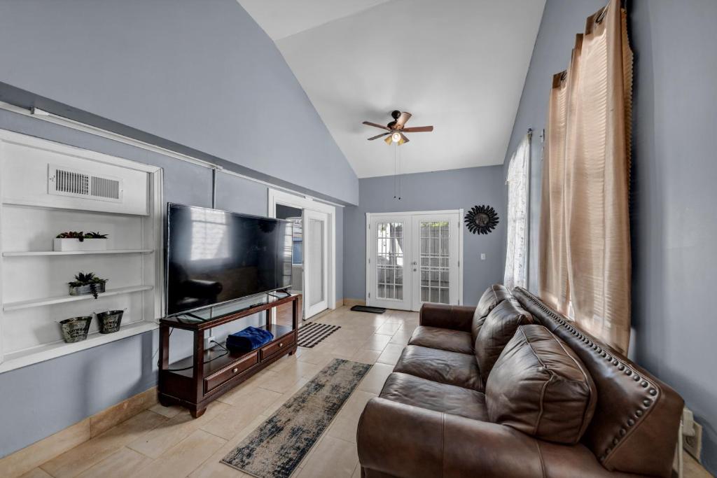 a living room with a leather couch and a flat screen tv at Charming Atlanta Home in Atlanta