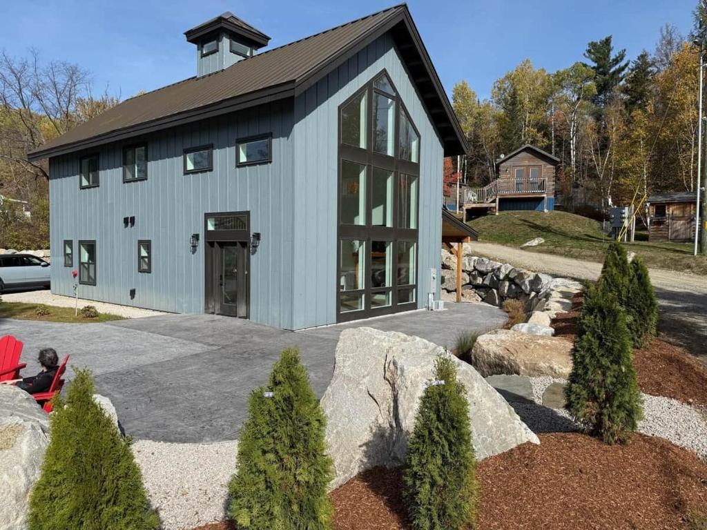 a house with a black roof and a garage at Vineyard Room @ Boulder Mountain View Barn in Twin Mountain