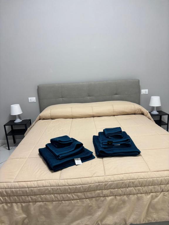 een bed met twee blauwe handdoeken erop bij GioNi HOUSE in Collegno